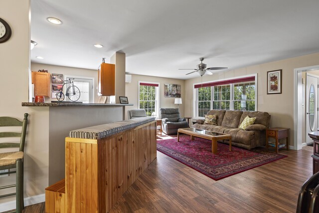 living room featuring dark wood-type flooring and ceiling fan