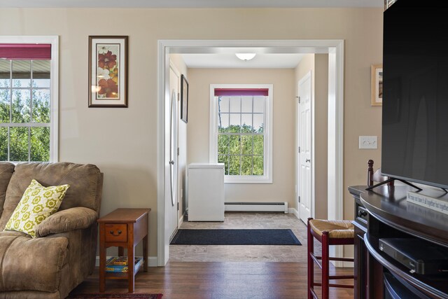 foyer entrance with a baseboard heating unit and dark wood-type flooring