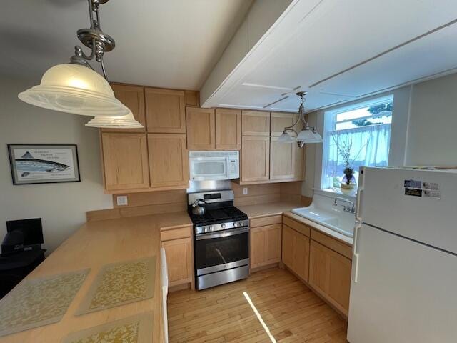 kitchen with light brown cabinetry, white appliances, light hardwood / wood-style floors, sink, and kitchen peninsula