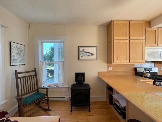 interior space featuring a baseboard radiator, light brown cabinets, light wood-type flooring, and gas stove