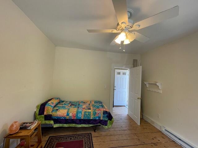 bedroom featuring ceiling fan, a baseboard radiator, and wood-type flooring