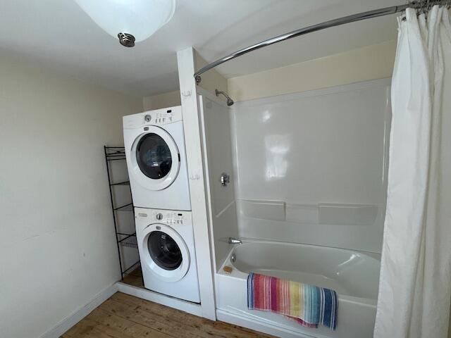 washroom featuring hardwood / wood-style floors and stacked washer and dryer