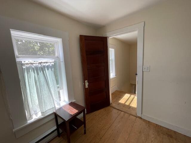 doorway to outside with a wealth of natural light, light hardwood / wood-style flooring, and baseboard heating