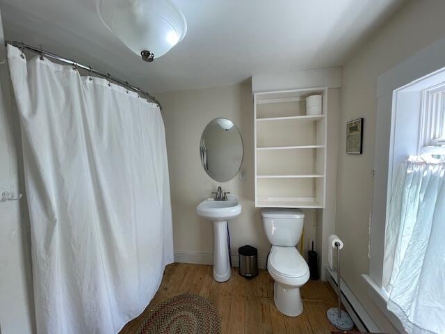 bathroom with wood-type flooring, toilet, walk in shower, and sink