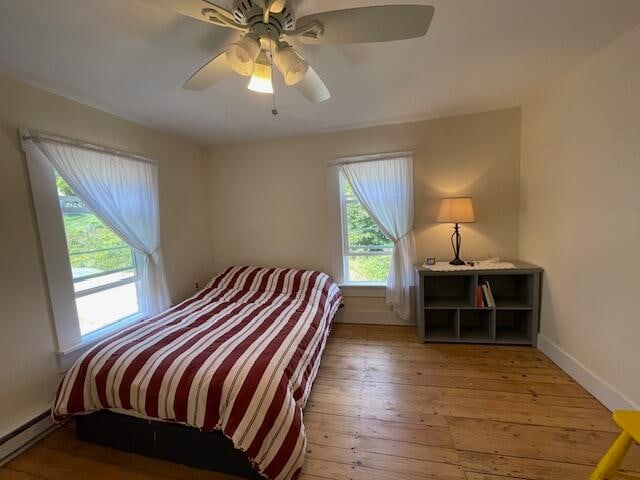 bedroom featuring a baseboard radiator, ceiling fan, and hardwood / wood-style flooring