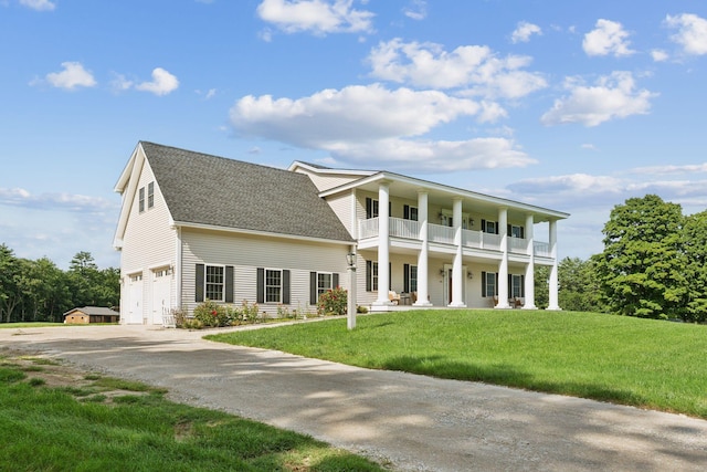 view of front facade featuring a balcony, a garage, covered porch, and a front yard