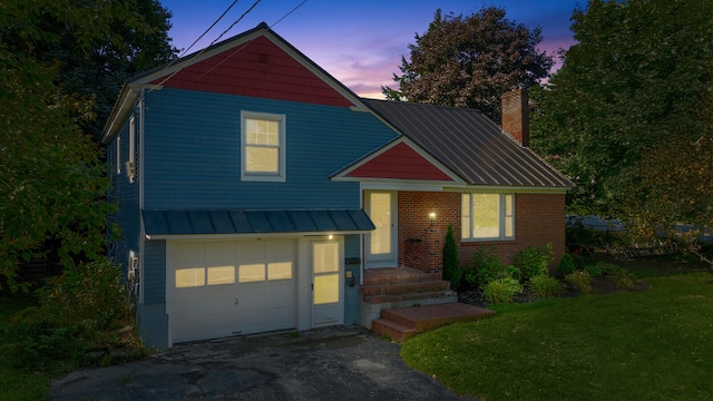 view of front of home featuring a lawn and a garage