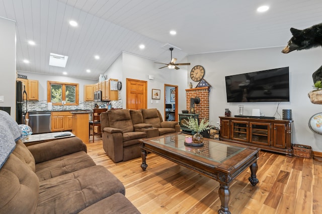 living room featuring wood ceiling, light hardwood / wood-style floors, vaulted ceiling, and a wood stove