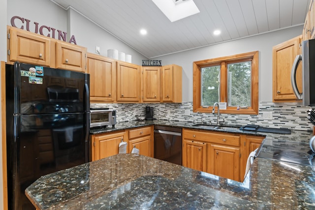 kitchen with lofted ceiling with skylight, sink, dishwashing machine, decorative backsplash, and black fridge