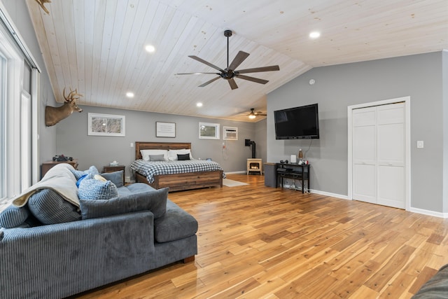 bedroom with wooden ceiling, vaulted ceiling, light hardwood / wood-style flooring, and a wood stove