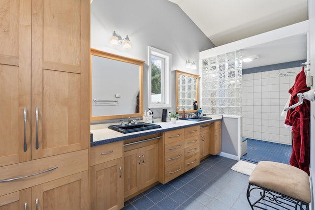 bathroom featuring lofted ceiling, tile walls, vanity, a shower, and tile patterned floors