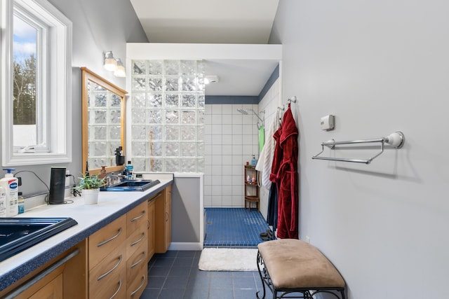 bathroom featuring walk in shower, vanity, and tile patterned flooring