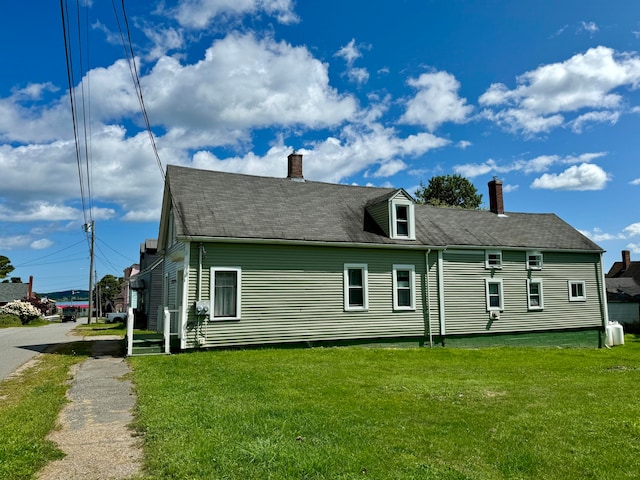 rear view of house featuring a yard