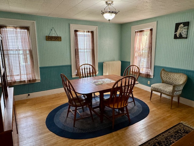 dining space featuring light wood-type flooring and radiator heating unit