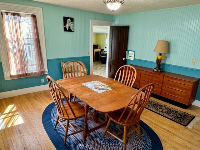 dining area featuring a wealth of natural light, light hardwood / wood-style floors, and a textured ceiling