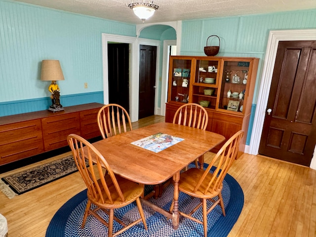 dining area with a textured ceiling and light hardwood / wood-style floors