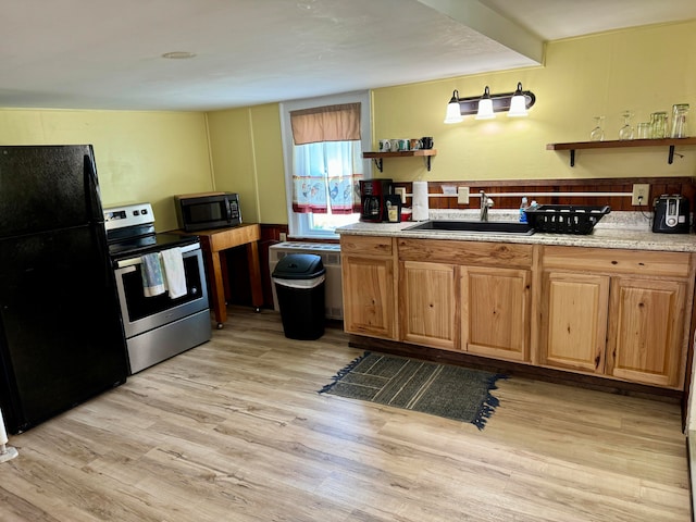 kitchen with light wood-type flooring, black appliances, and sink