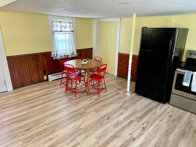 dining space with light wood-type flooring and baseboard heating