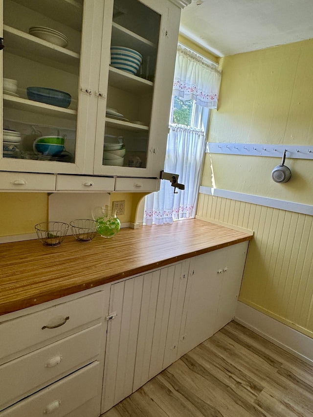 kitchen featuring white cabinetry, light hardwood / wood-style flooring, and wood counters