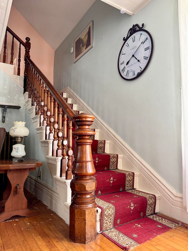 stairway featuring wood-type flooring and vaulted ceiling