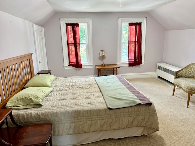 bedroom featuring radiator, vaulted ceiling, multiple windows, and carpet flooring