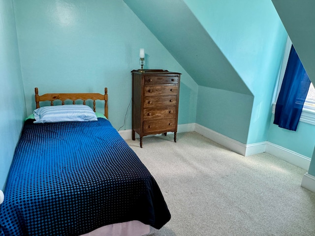 bedroom featuring lofted ceiling and carpet