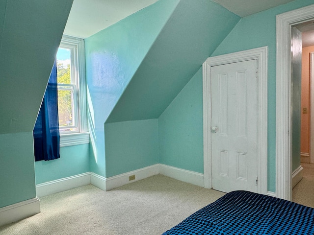 unfurnished bedroom with carpet and vaulted ceiling