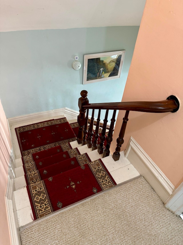 stairway with lofted ceiling and carpet flooring