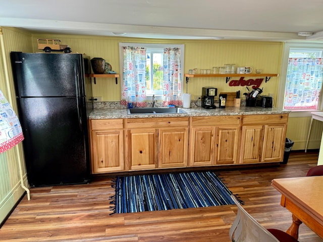 kitchen featuring black fridge, hardwood / wood-style floors, and sink