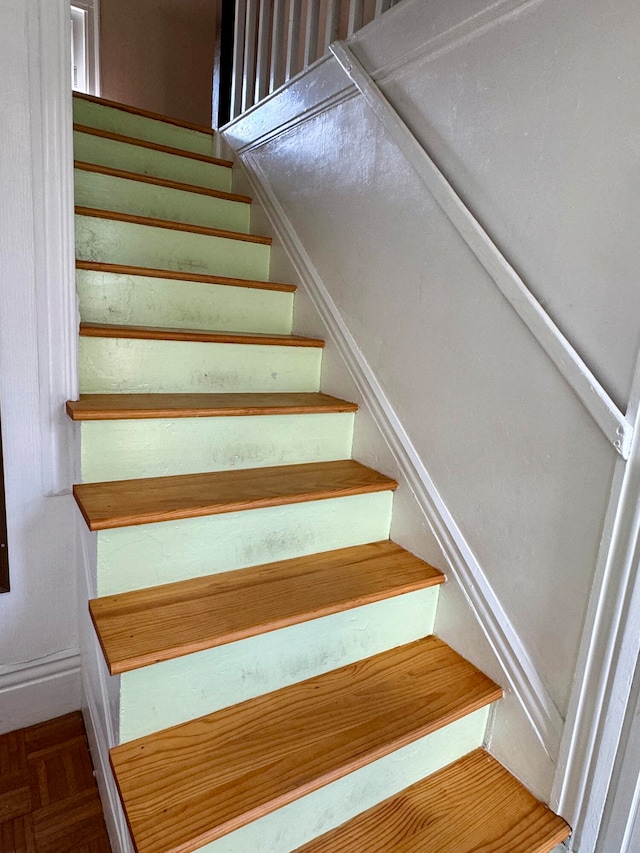 stairway featuring parquet floors