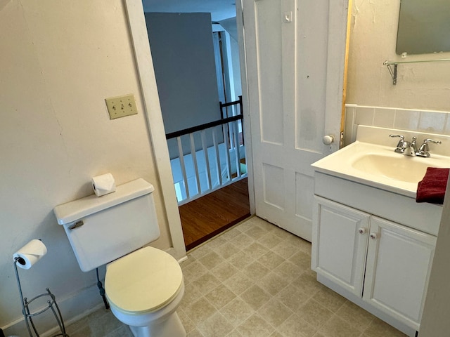 bathroom featuring wood-type flooring, toilet, and vanity