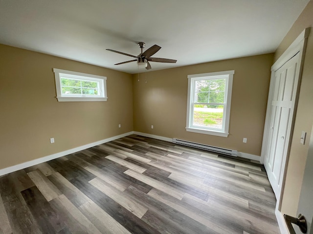 unfurnished bedroom featuring baseboard heating, hardwood / wood-style flooring, and ceiling fan