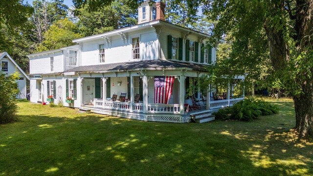 back of house featuring a yard and covered porch