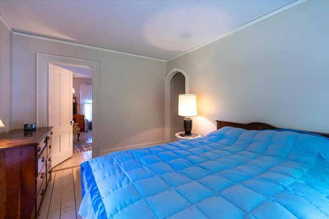 bedroom with ornamental molding and wood-type flooring