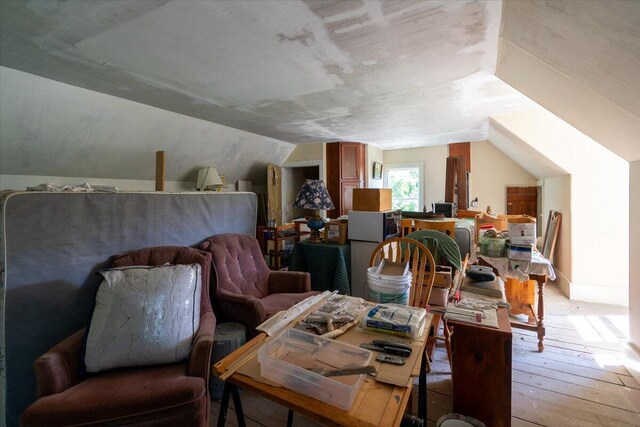 additional living space with light hardwood / wood-style flooring and vaulted ceiling