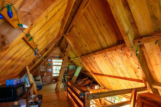 292300 Main Rd, Islesboro, ME 04848 - additional living space with hardwood / wood-style flooring, wooden walls, vaulted ceiling, and a wood stove