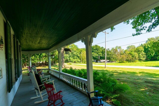 wooden terrace featuring a yard