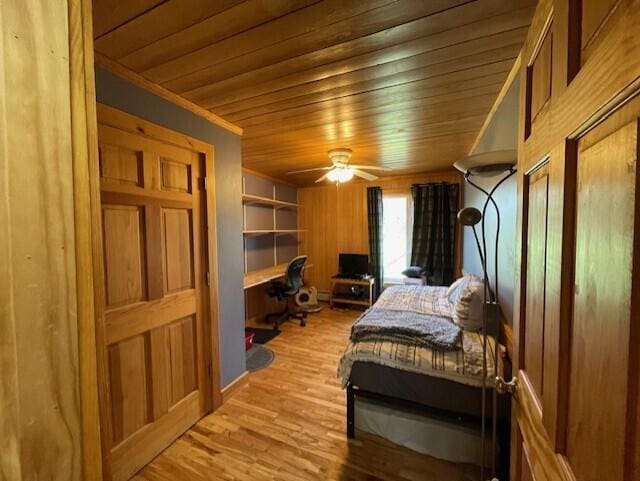 bedroom with wood walls, ceiling fan, hardwood / wood-style flooring, and wooden ceiling