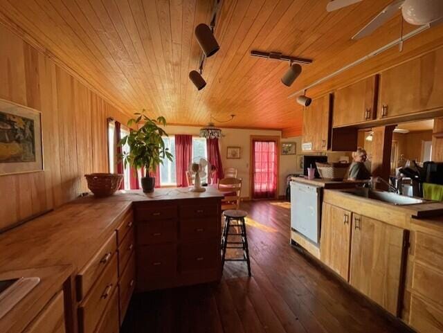 kitchen with dark wood-type flooring, wood walls, a kitchen breakfast bar, and wooden ceiling