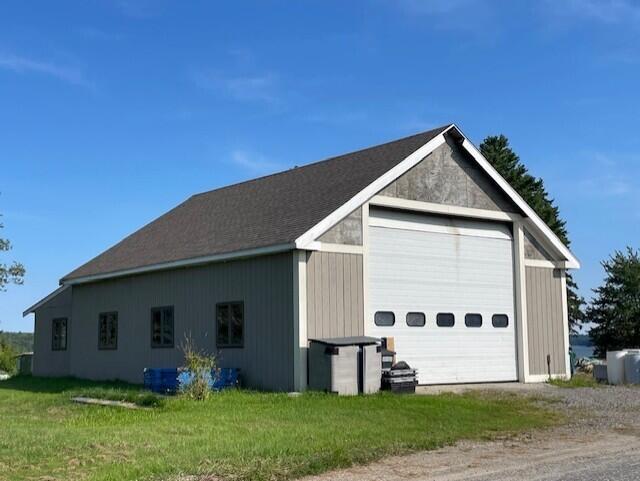 exterior space with an outdoor structure, a garage, and a yard