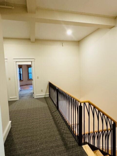 hallway featuring carpet and beam ceiling