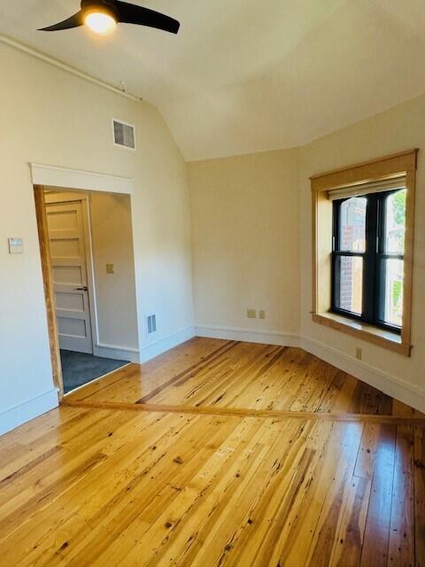 spare room featuring lofted ceiling, ceiling fan, and hardwood / wood-style flooring