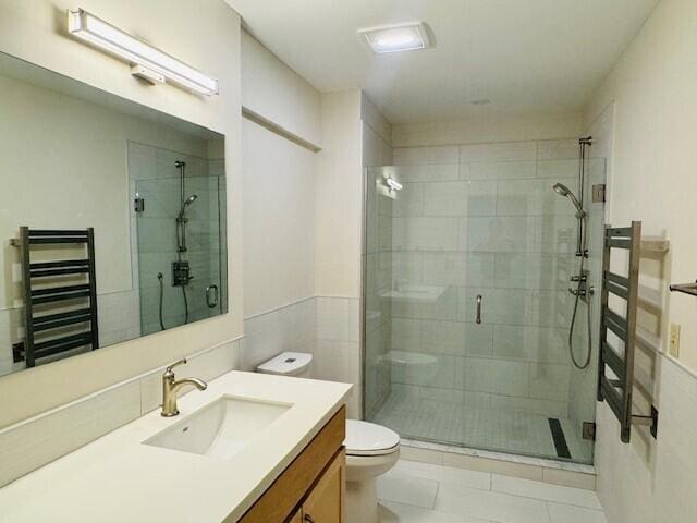 bathroom with tile patterned flooring, walk in shower, toilet, radiator heating unit, and vanity