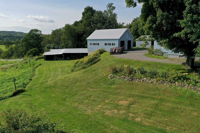 view of front of property with a front yard, an outbuilding, and a rural view