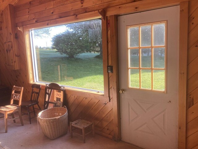 entryway with wood walls and carpet floors