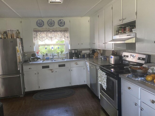 kitchen featuring appliances with stainless steel finishes, backsplash, white cabinetry, and sink