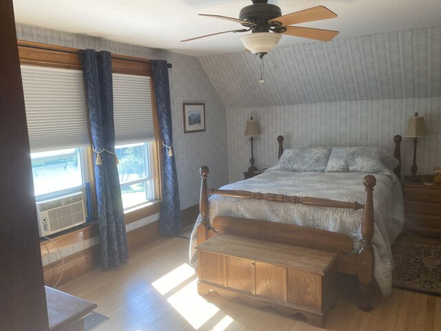 bedroom with lofted ceiling, light hardwood / wood-style flooring, ceiling fan, and cooling unit