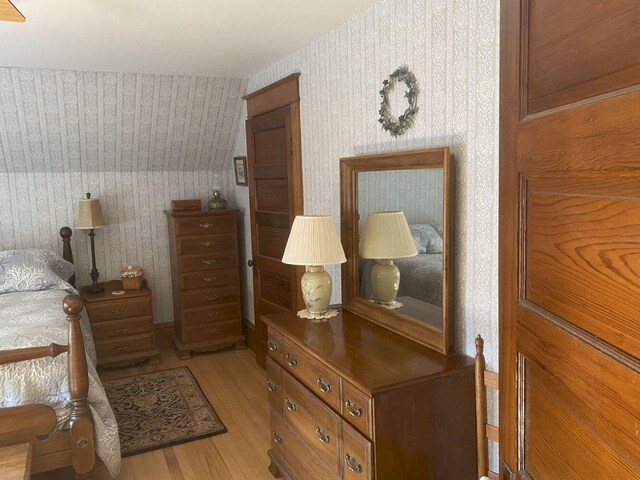 bedroom with lofted ceiling and light hardwood / wood-style floors