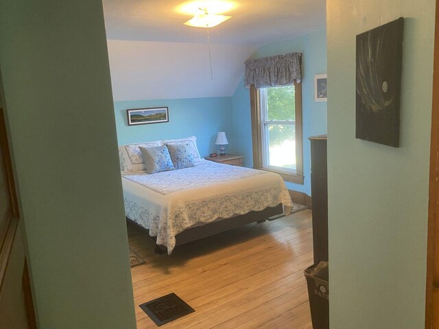 bedroom featuring lofted ceiling and light hardwood / wood-style floors