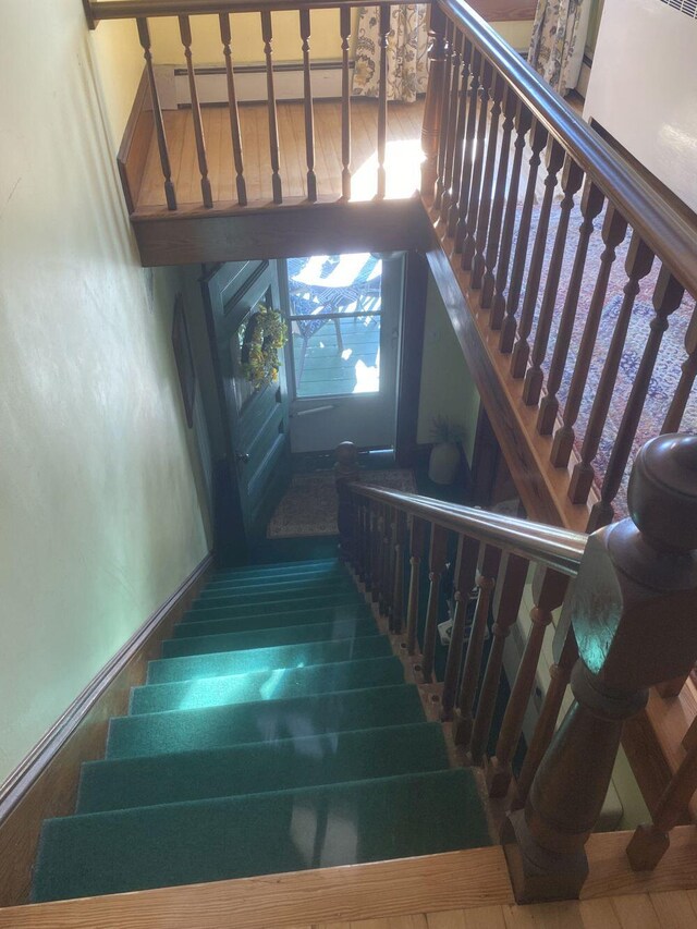 stairway featuring a baseboard radiator and hardwood / wood-style floors